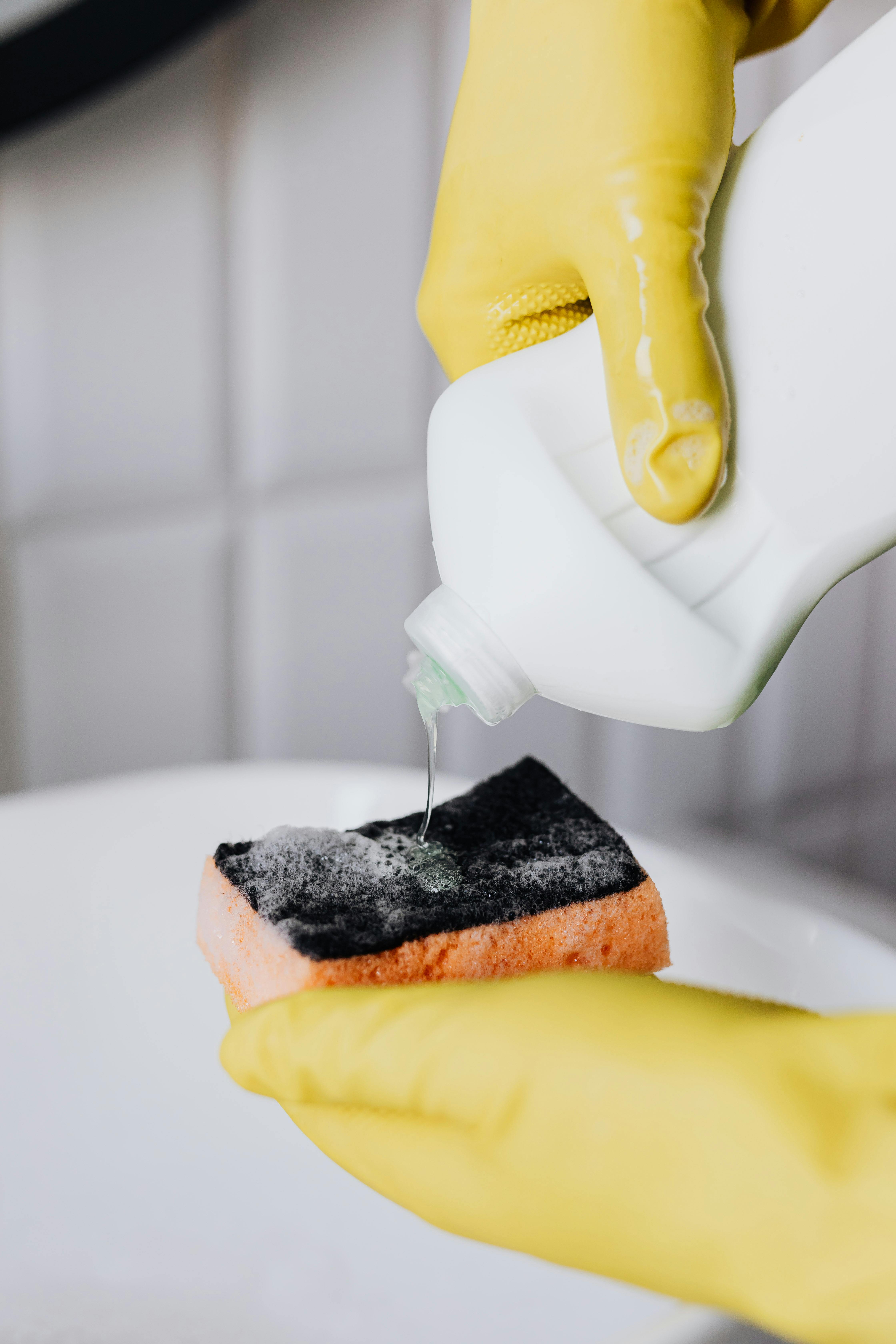 Cleaning products being poured onto a sponge